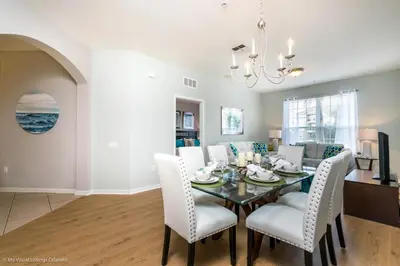 a dining room and living room with a table and chairs at Spacious Condo Near Convention Ctr & I-Drive, Pool in Orlando