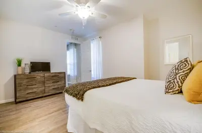a white bedroom with a bed and a television at Lovely Condo w FREE Access to Resort Amenities in Orlando