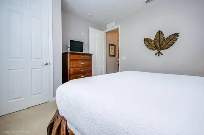 a bedroom with a bed and a dresser and a television at LAKEVIEW Condo at Vista Cay Resort in Orlando