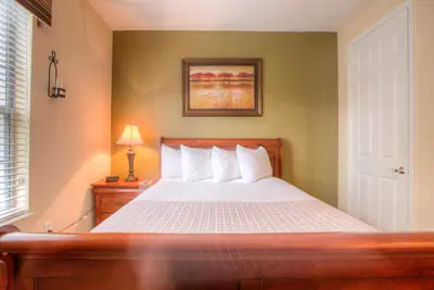 a bedroom with a bed with white sheets at Stylish Condo at Vista Cay Resort Minutes to WDW in Orlando