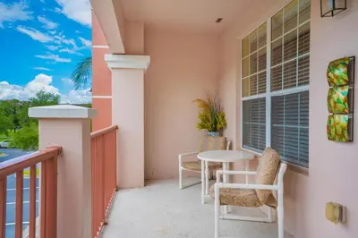 a balcony with a table and chairs and a window at Beautiful Condo at Vista Cay Resort Near WDW in Orlando