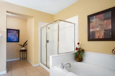 a bathroom with a tub and a glass shower at Beautiful Condo at Vista Cay Resort Near WDW in Orlando
