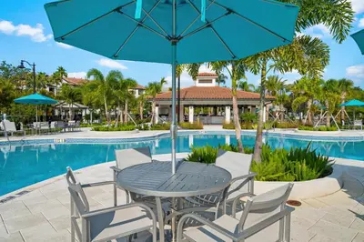 a table and chairs with an umbrella next to a pool at Stylish Vista Cay Condo, near Orlando attractions in Orlando