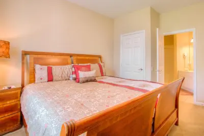 a bedroom with a wooden bed with red pillows at Lovely Vista Cay Resort Condo, Near ClubhousePool in Orlando