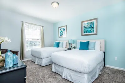 two beds in a room with blue walls at Majestic Holiday in Orlando