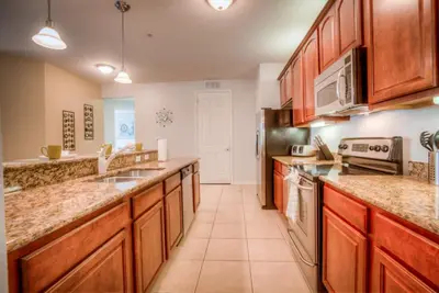 a large kitchen with wooden cabinets and appliances at Beautiful LAKEVIEW Deluxe Condo Near Theme Parks in Orlando