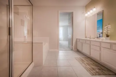 a bathroom with a walk in shower and a sink at Beautiful LAKEVIEW Deluxe Condo Near Theme Parks in Orlando