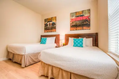 two beds in a room with two windows at Newly Renovated LAKEVIEW Vista Cay Condo in Orlando