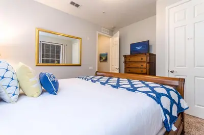 a bedroom with a bed with blue and white pillows at Spacious Condo in Vista Cay Resort LUXURY AWAITS in Orlando
