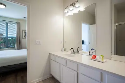 a white bathroom with a sink and a mirror at 3-Story Townhome at Vista Cay Resort in Orlando