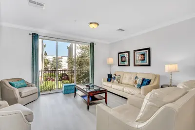 a living room with white furniture and a large window at NEWLY RENOVATED Townhome, Near Universal & I-Drive in Orlando
