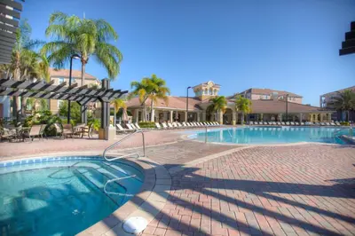 a swimming pool with palm trees and a resort at Beautiful Newly Updated Townhome Sleeps 10 in Orlando