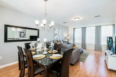 a dining room and living room with a table and chairs at Beautiful Newly Updated Townhome Sleeps 10 in Orlando