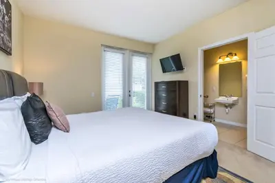 a bedroom with a large white bed and a sink at Spacious Vista Cay Townhome Newly Furnished in Orlando