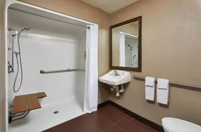 a bathroom with a shower toilet and a sink at Staybridge Suites Orlando South by IHG in Orlando