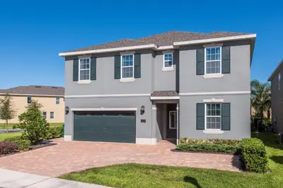 a large house with a garage at Splendid Home With Private Pool, Loft Area, Waterpark & Resort Access Near Disney At Encore Resort - 7619Br in Kissimmee