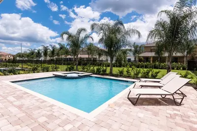 a swimming pool with two lounge chairs next to a resort at Welcoming Home With Private Pool Near Disney With Waterpark & Resort Access At Encore Resort - 761La in Kissimmee