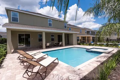 a swimming pool with two chairs and a house at Welcoming Home With Private Pool Near Disney With Waterpark & Resort Access At Encore Resort - 761La in Kissimmee