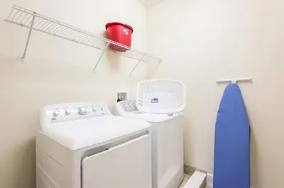 a laundry room with a washing machine and a red mug at Elegant Home Near Disney With Private Pool And Waterpark & Resort Access At Encore Resorts Reunion - 621La in Kissimmee
