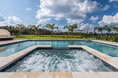 a swimming pool with palm trees in the background at Exquisite Home With Themed Rooms, Theater Near Disney With Waterpark & Resort Access At Encore Resort - 7736Ff in Orlando