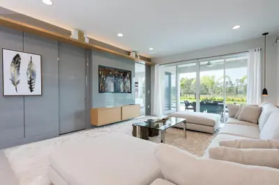 a living room with a white couch and a table at Exquisite Home With Themed Rooms, Theater Near Disney With Waterpark & Resort Access At Encore Resort - 7736Ff in Orlando