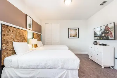 two beds in a bedroom with white walls at Luxurious Home Near Disney With Game Room And Waterpark & Resort Access At Encore Resorts Reunion - 371Fl in Kissimmee