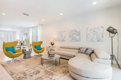 a living room with a white couch and two yellow chairs at Luxurious Home Near Disney With Game Room And Waterpark & Resort Access At Encore Resorts Reunion - 371Fl in Kissimmee