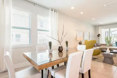 a dining room with a glass table and white chairs at Luxurious Home Near Disney With Game Room And Waterpark & Resort Access At Encore Resorts Reunion - 371Fl in Kissimmee