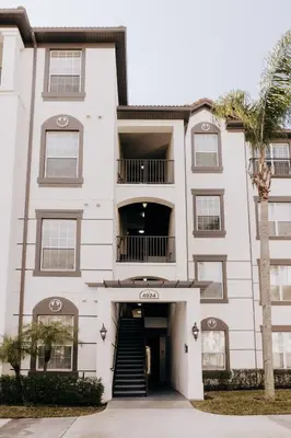 a white building with a staircase in front of it at Vista Cay Inn in Orlando