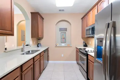 a kitchen with wooden cabinets and stainless steel appliances at Orlando Resort Rentals at Universal Boulevard in Orlando