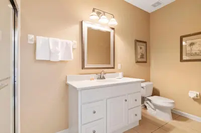 a bathroom with a sink and a toilet and a mirror at Orlando Resort Rentals at Universal Boulevard in Orlando