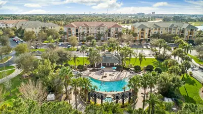 an aerial view of a resort with a pool and palm trees at Orlando Resort Rentals at Universal Boulevard in Orlando
