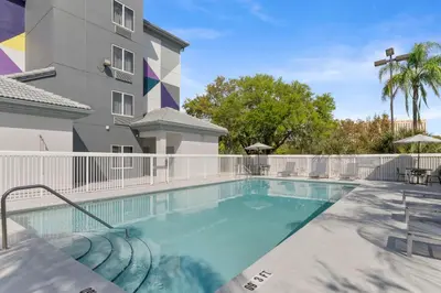 a swimming pool in front of a building at Spark by Hilton Orlando near SeaWorld in Orlando