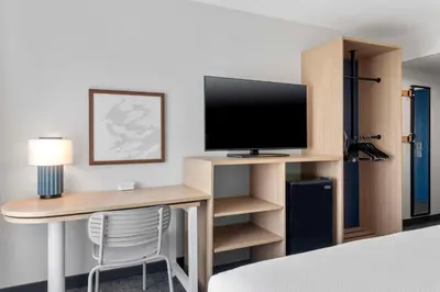a room with a desk with a tv and a computer monitor at Spark by Hilton Orlando near SeaWorld in Orlando