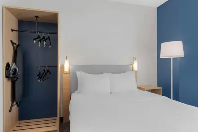 a bedroom with a large white bed and blue walls at Spark by Hilton Orlando near SeaWorld in Orlando