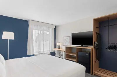 a hotel room with a bed and a flat screen tv at Spark by Hilton Orlando near SeaWorld in Orlando