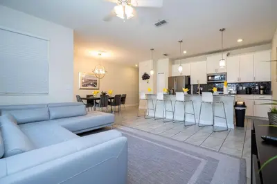 a living room and kitchen with a couch and a table at Family Friendly Four Bedrooms w/ Pool 4896 in Kissimmee