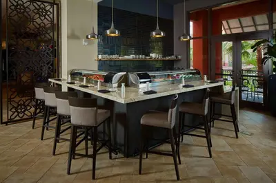 a bar in a restaurant with chairs around it at Wyndham Grand Orlando Resort Bonnet Creek in Orlando