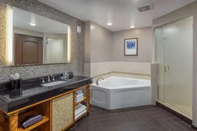 a bathroom with a tub and a sink and a mirror at Wyndham Grand Orlando Resort Bonnet Creek in Orlando