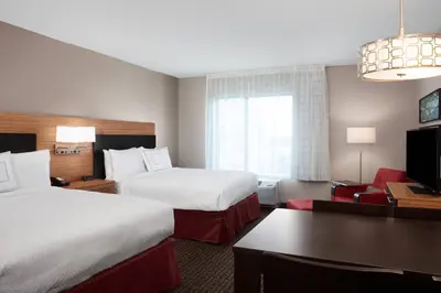 a hotel room with two beds and a desk at TownePlace Suites by Marriott Orlando Theme Parks Lake Buena Vista in Orlando