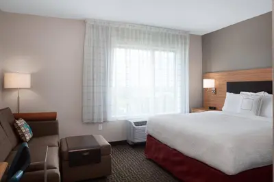 a hotel room with a bed and a couch at TownePlace Suites by Marriott Orlando Theme Parks Lake Buena Vista in Orlando
