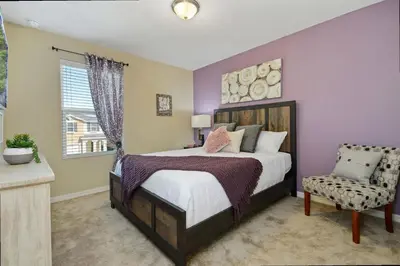a bedroom with a bed and a chair and a window at Family Friendly 4 Bedroom Close to Disney 5148 in Kissimmee