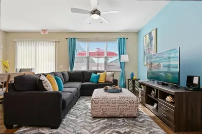 a living room with a couch and a flat screen tv at Family Friendly 4 Bedroom Close to Disney 5148 in Kissimmee