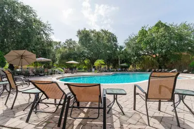 a group of chairs and a swimming pool at Four Bedroom w/ GameRoom 5152A in Kissimmee
