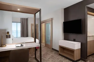 a hotel room with a bed and a desk and a tv at SpringHill Suites by Marriott Orlando Theme Parks Lake Buena Vista in Orlando