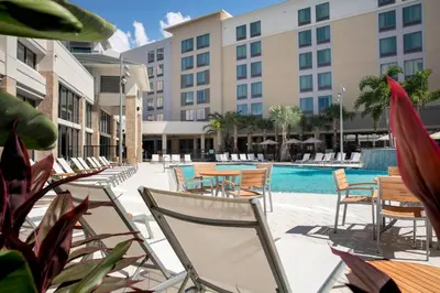 a hotel patio with chairs and a swimming pool at SpringHill Suites by Marriott Orlando Theme Parks Lake Buena Vista in Orlando