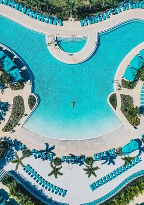 an overhead view of a large swimming pool with blue umbrellas at Margaritaville Resort Orlando with H2O Waterpark in Kissimmee