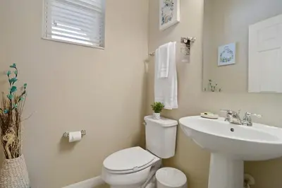 a white bathroom with a toilet and a sink at Four Bedroom with GameRoom 5150A in Kissimmee