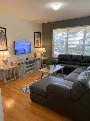 a living room with a couch and a flat screen tv at Disney World Vacation.. Luxury 6 BR/4 BA 5 Star Villa in Orlando