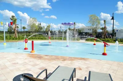 a pool with a water fountain in a park at Four Bedrooms with Screen PoolStoreyLake 4910 in Kissimmee